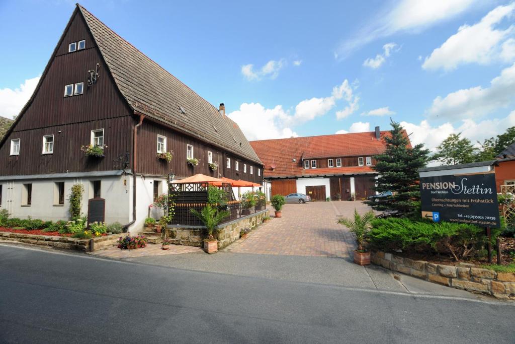 a large brown and white building next to a street at Pension Stettin in Stadt Wehlen