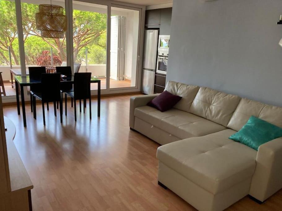 ein Wohnzimmer mit einem Sofa und einem Esstisch in der Unterkunft Apartamento Edificio Lirios Politur in Platja  d'Aro