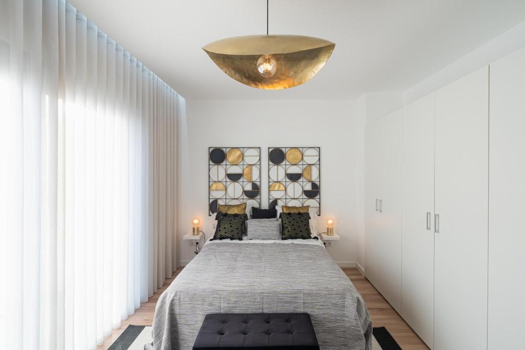 a bedroom with a bed and a chandelier at Lugar d ribeira in Lagoa