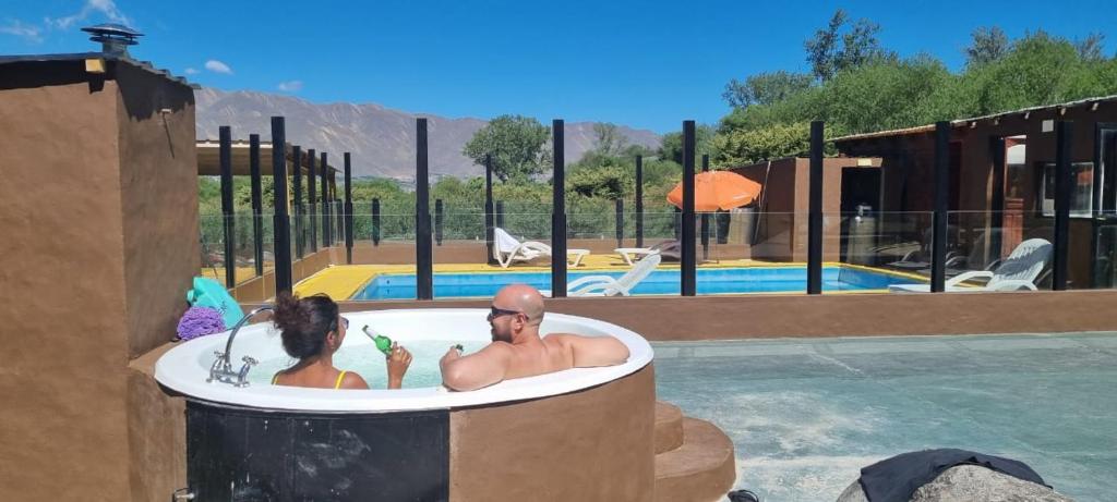 um homem e uma mulher numa banheira numa piscina em Descanso de las Piedras em Tafí del Valle