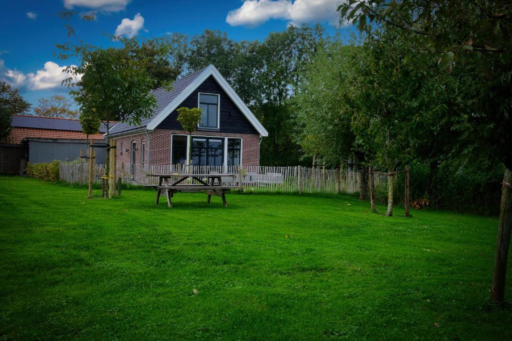 ein Haus mit einem Picknicktisch im Hof in der Unterkunft Het Gouwe Boetje in Hoogwoud