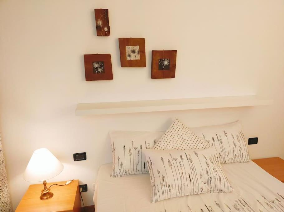 a bedroom with a bed with pillows and pictures on the wall at La Casina di Borgo in Borgo San Lorenzo