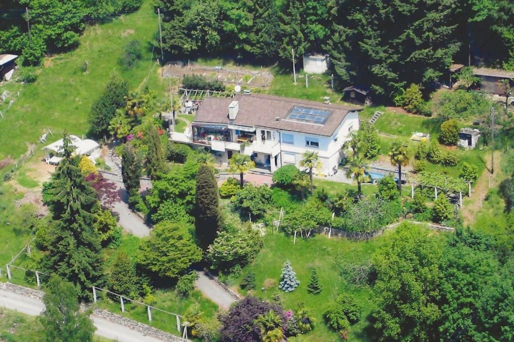 eine Aussicht auf ein großes Haus auf einem Hügel in der Unterkunft Il Bell'Ovile, bellissima villa nel verde, con privacy garantita in Novaggio