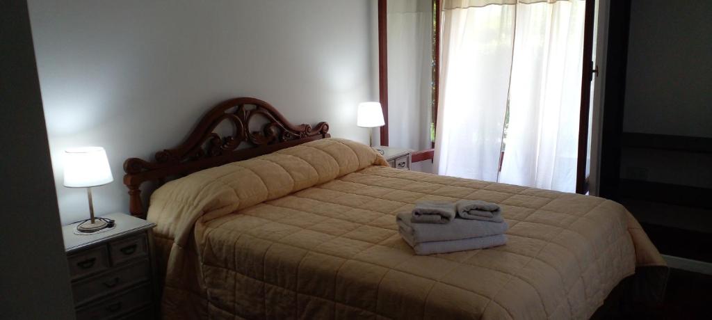 1 dormitorio con 1 cama con 2 toallas en Casa Cristal en Villa General Belgrano