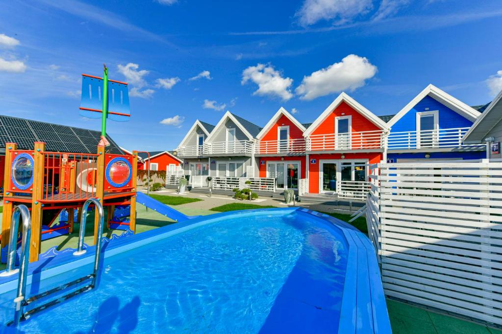 a pool in front of a row of houses at Kotwisko in Sarbinowo