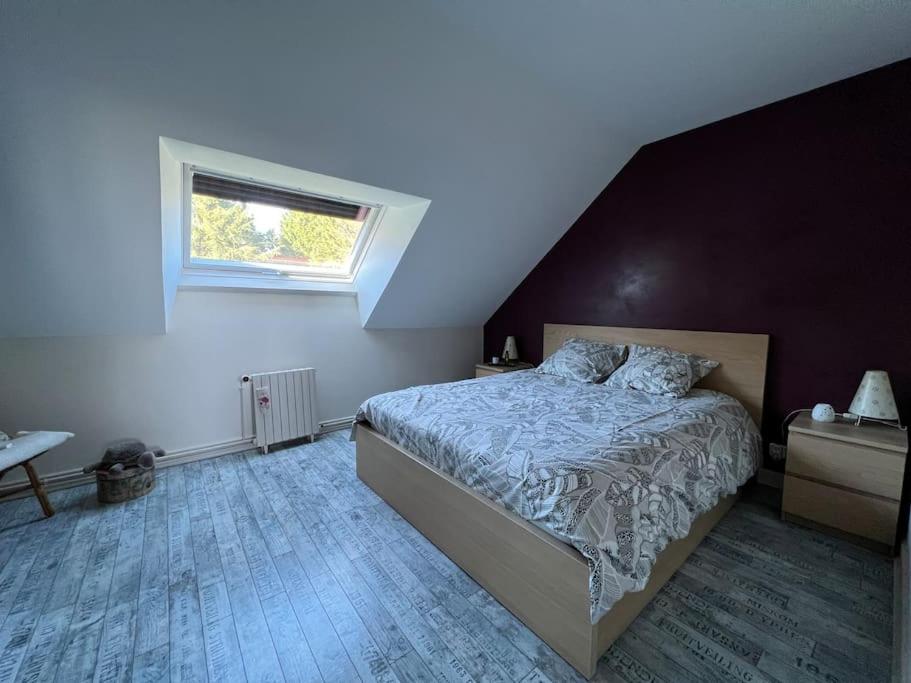 a bedroom with a large bed and a window at Le Cabaret Paisible avec Piscine in Montierchaume