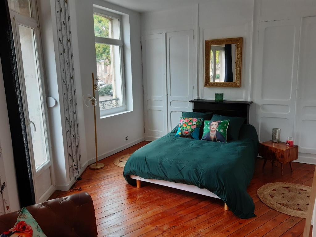 um quarto com uma cama com um cobertor verde em Amiens magnifique appartement Frida em Amiens