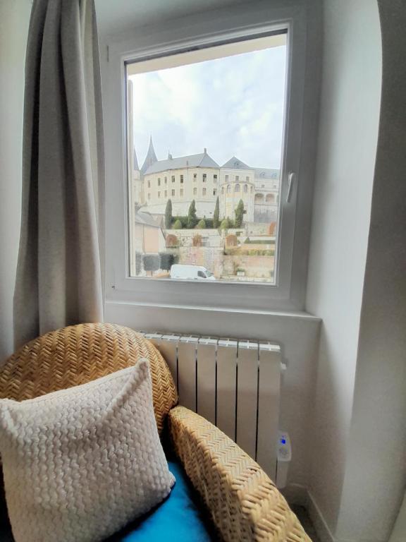 une fenêtre avec une chaise en osier à côté d'un radiateur dans l'établissement Côté Château, à Gaillon
