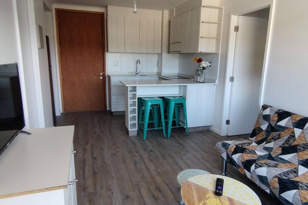 uma cozinha com um balcão e bancos num quarto em Comfortable and quiet apartment. Pelluco Alto em Puerto Montt