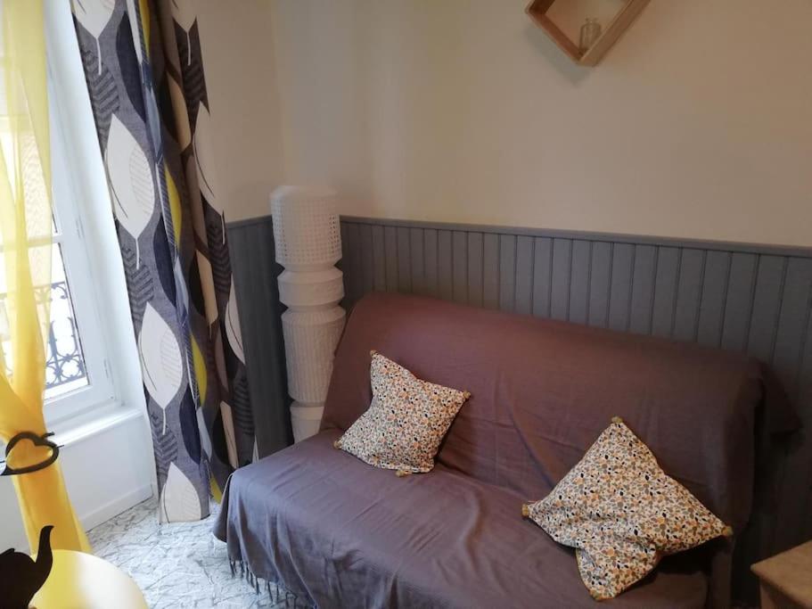 a bed with two pillows on it in a room at Le nid douillet Univers in La Bourboule