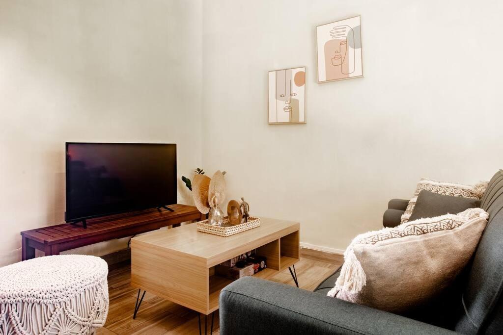 sala de estar con TV, sofá y mesa en Aparment Playa Venao - D en Pedasí Town