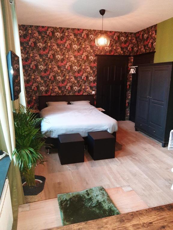 1 dormitorio con cama y papel pintado con motivos florales en Herberg Lambic, en Blitterswijck