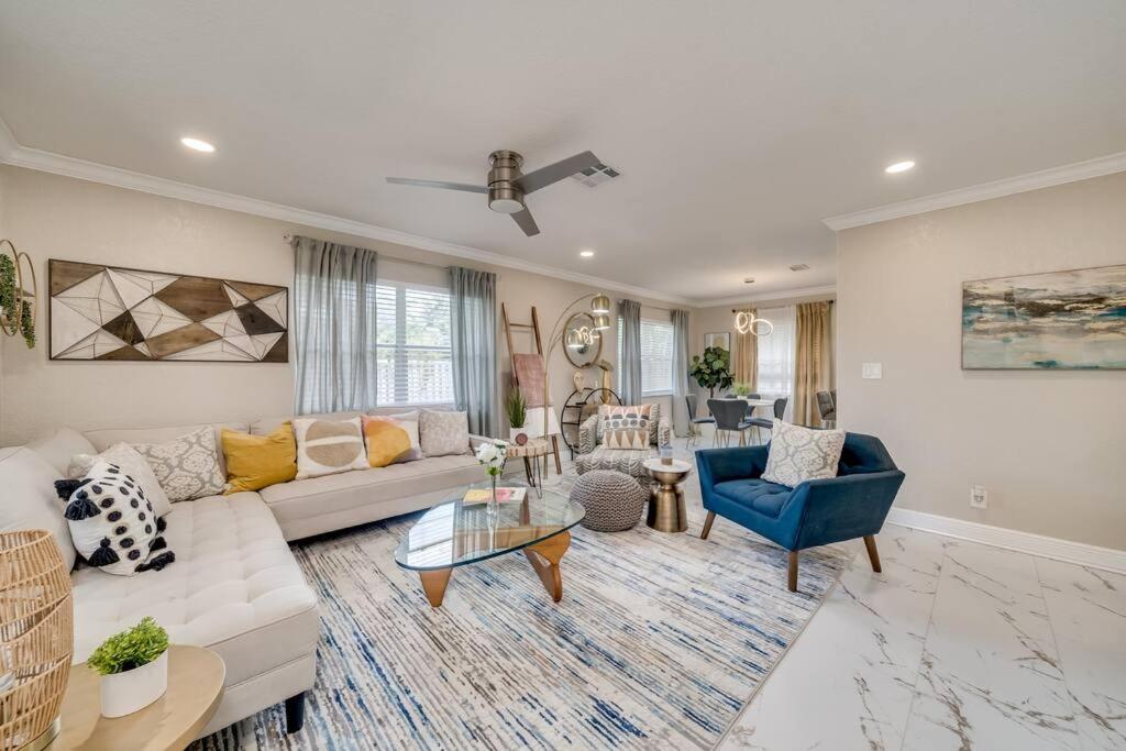 a living room with a white couch and blue chairs at Modern home 10 minutes from Fort Lauderdale beach! in Fort Lauderdale