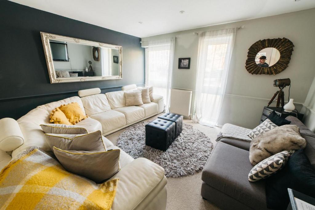 a living room with a white couch and a mirror at Holloway House in Bath