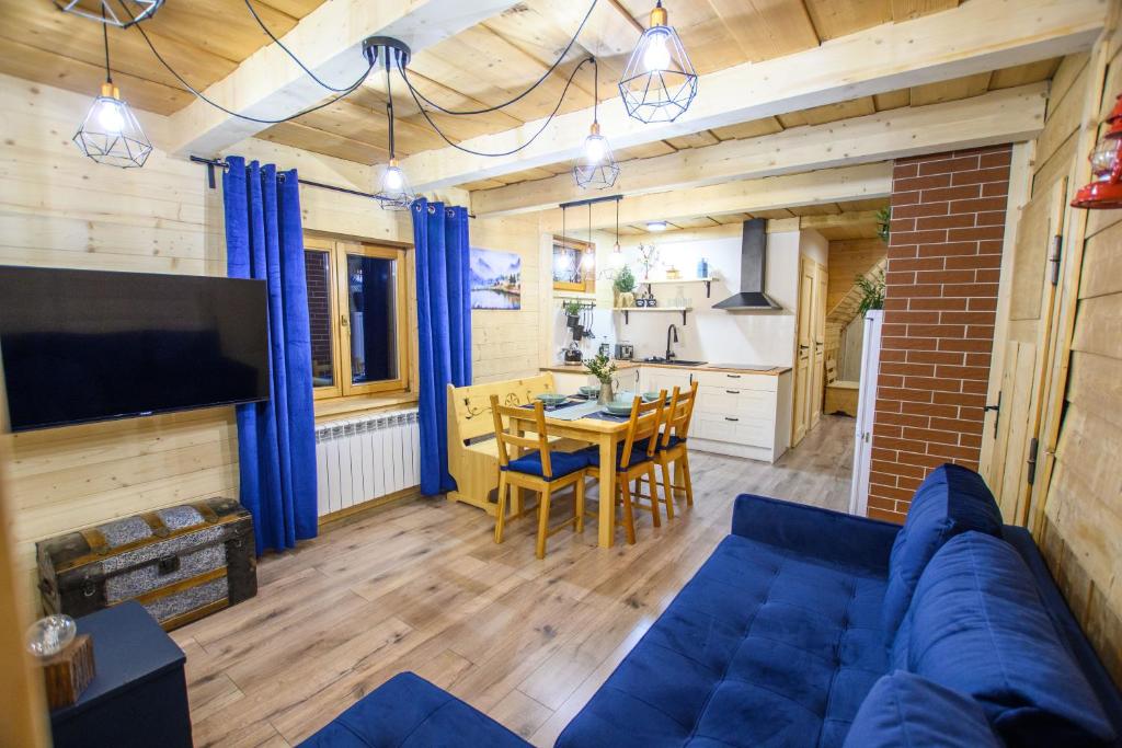 uma sala de estar com um sofá azul e uma mesa em Apartament Stryszek Alpinistyczny em Bukowina Tatrzańska