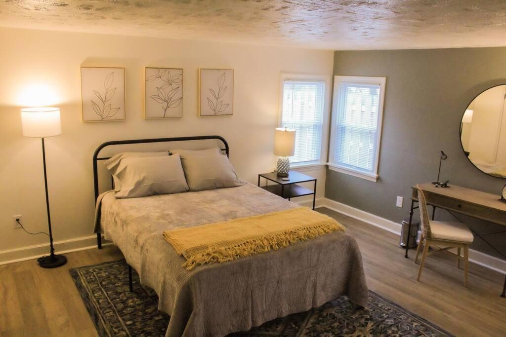 a bedroom with a bed and a table and a mirror at New 1-bedroom Bungalow! 4 miles to CLE in Berea