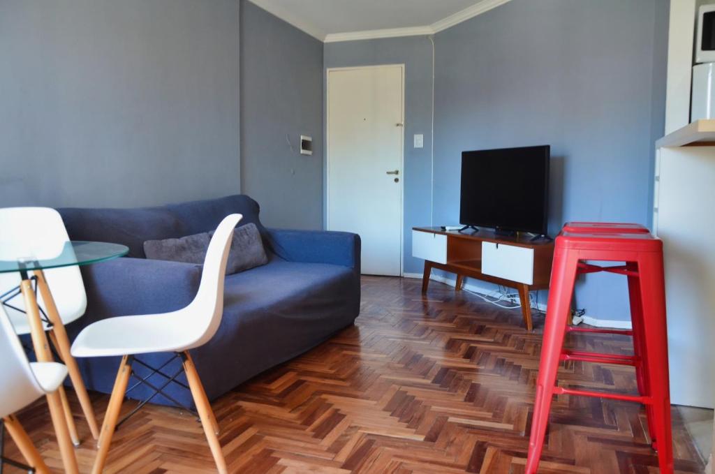 a living room with a blue couch and a red stool at Apartamento Nueva Córdoba in Cordoba