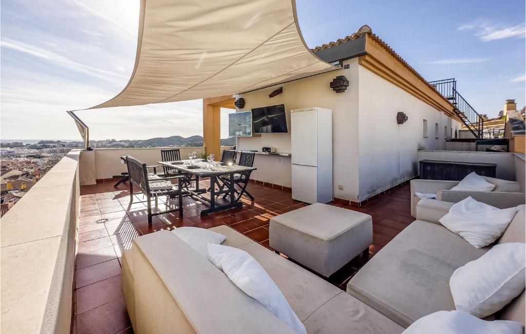 a balcony with a couch and a table on a roof at Lovely Apartment In Las Lagunas De Mijas With Kitchen in Fuengirola