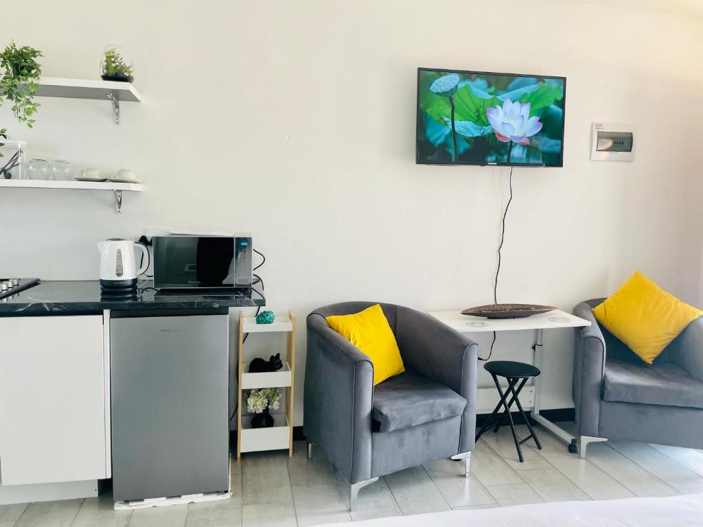 een keuken met 2 stoelen, een tafel en een aanrecht bij Mo’Ville Guest House in Maseru