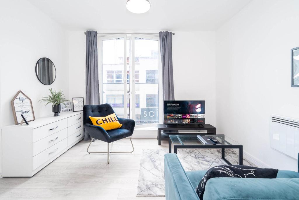 ein Wohnzimmer mit einem Sofa und einem Stuhl in der Unterkunft Vibrant 1 Bedroom Cosy Apartment - City Centre in Birmingham