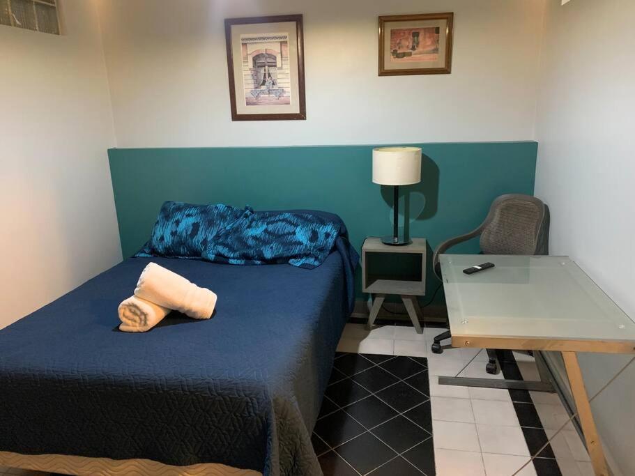 una camera con un letto blu e un tavolo di Buganvilias 11 a Città del Messico