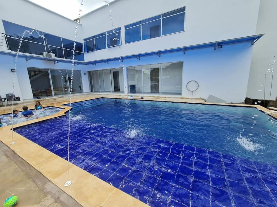 a large pool with blue water in a building at La Higuera, Casa Campestre. in El Asilo
