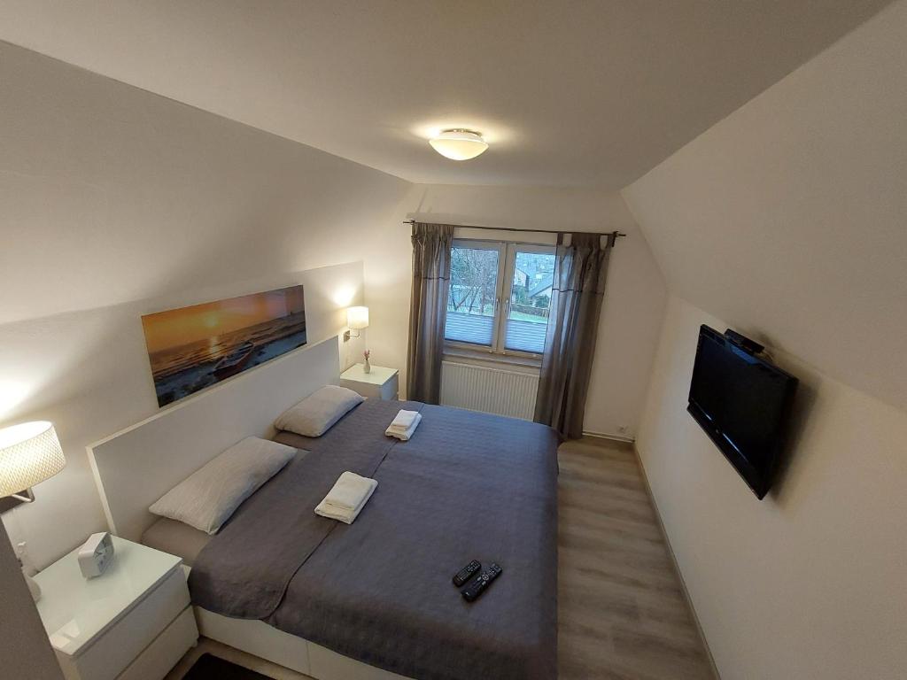 1 dormitorio con 1 cama grande y TV en Ferienhaus an der Bergmühle, en Flensburg