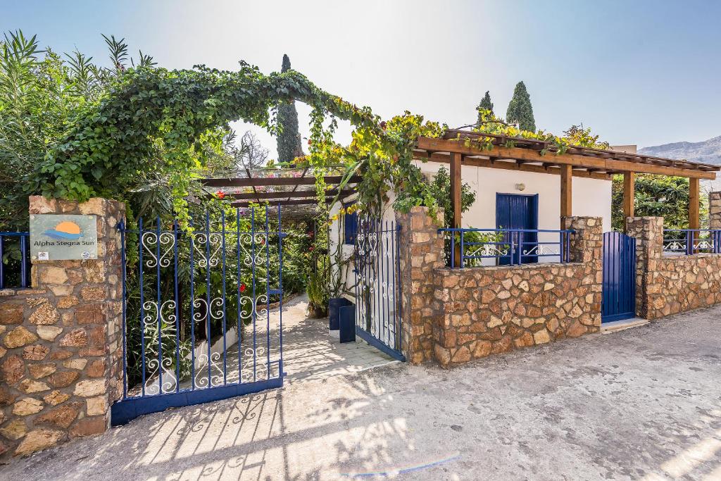 an entrance to a stone building with a blue gate at Alpha Stegna Sun in Archangelos