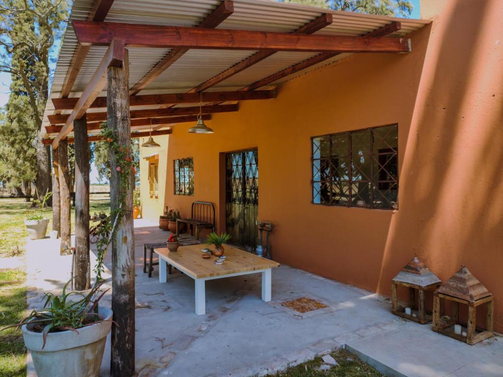 un patio de una casa con pérgola de madera en Inti, hospedaje de campo. en Arrecifes