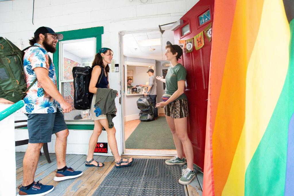 a group of people standing in a room with a rainbow door at CoHo: Conway Hostel in Conway