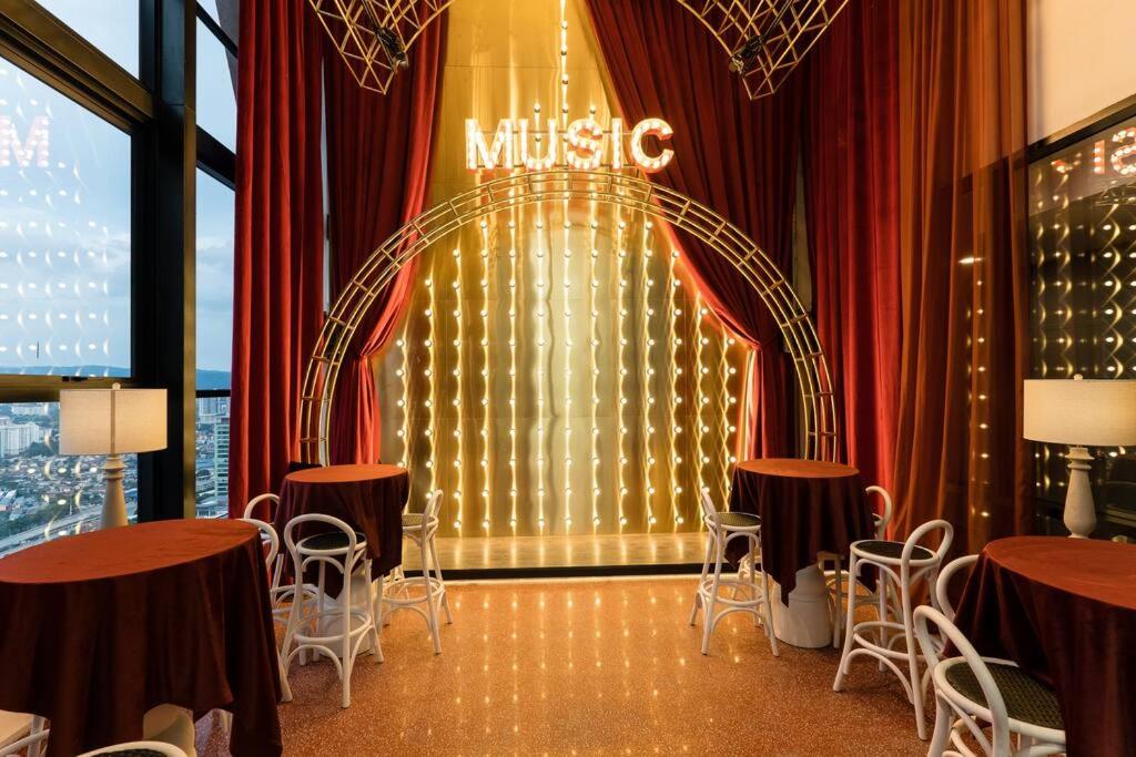 een muziekkamer met tafels en stoelen en een podium bij KLCC MusicalSty5Pax AT ScarletzSuites in Kuala Lumpur