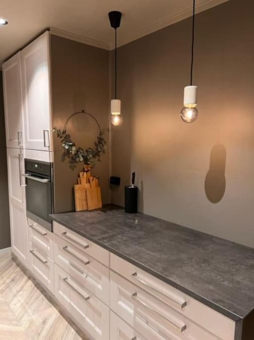 a kitchen with white cabinets and a counter top at Skogro ved Norefjell in Noresund