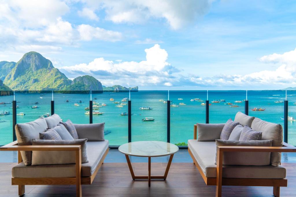 uma sala de estar com vista para o oceano em H Hotel El Nido - Vegan Friendly Hotel em El Nido