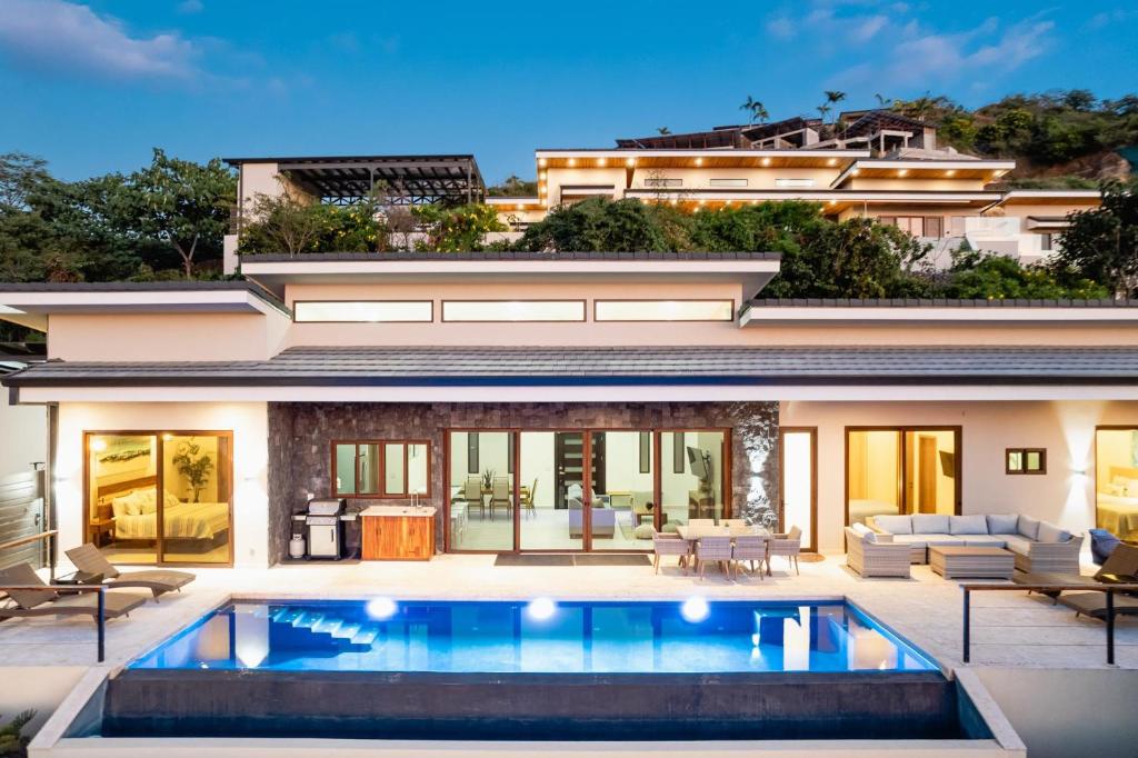 an exterior view of a house with a swimming pool at Casa Sunset At Mar Vista in Playa Flamingo