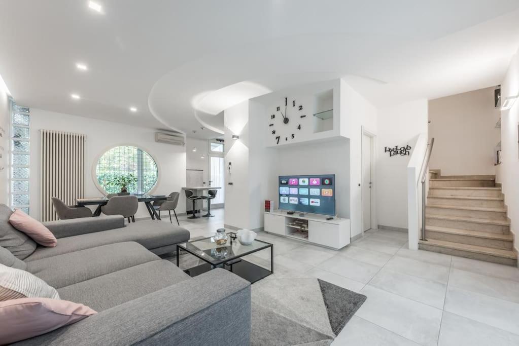 ein Wohnzimmer mit einem Sofa und einem TV in der Unterkunft Villa con giardino in piena città in Modena