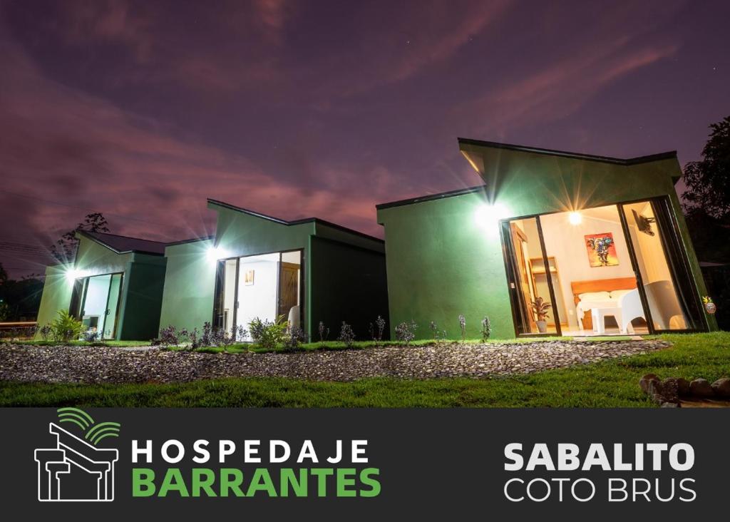 una casa con una fachada verde por la noche en Hospedaje Barrantes, en Coto Brus