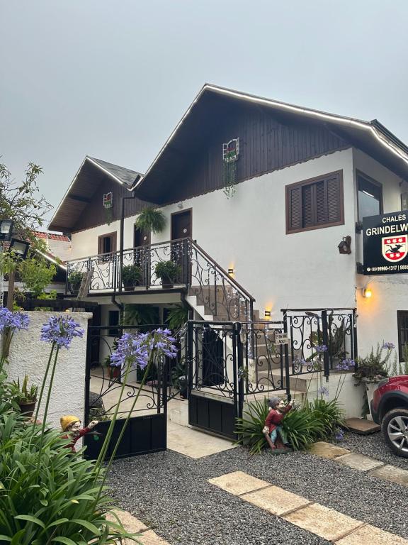 Biały dom ze schodami przed nim w obiekcie Chalés Grindelwald w mieście Monte Verde
