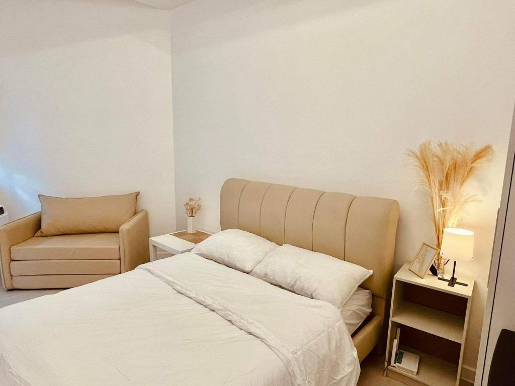 a bedroom with a bed and a chair at Minimalist Condo in Azure North in San Fernando