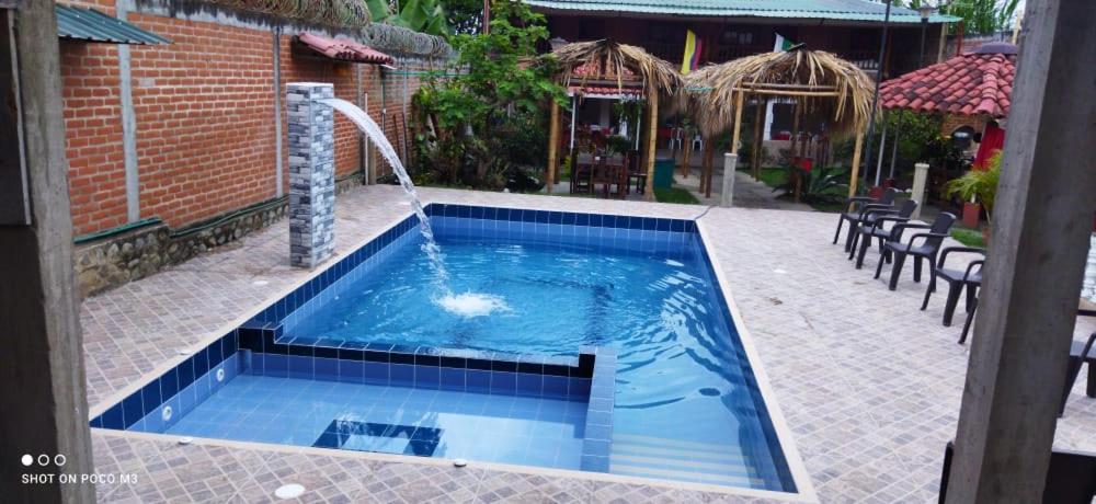 a pool with a water fountain in a yard at El Buen Sazon Valluno 