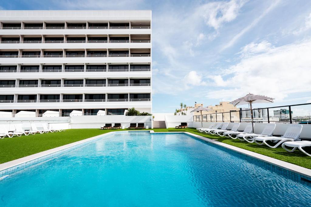uma piscina em frente a um edifício em The Benson Hotel em Cairns