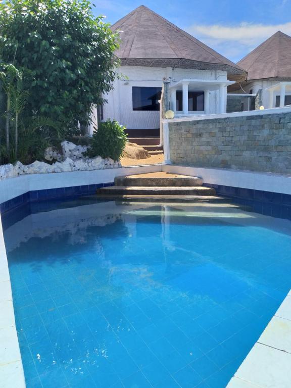 una piscina de agua azul frente a una casa en SujungSesang Dive Resort, en Agus