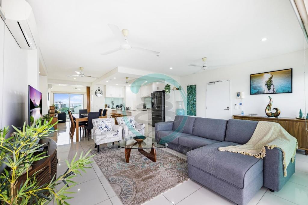 uma sala de estar com um sofá e uma mesa em ZEN BY THE WATER - Darwin's Premier Ocean View Family Retreat em Darwin