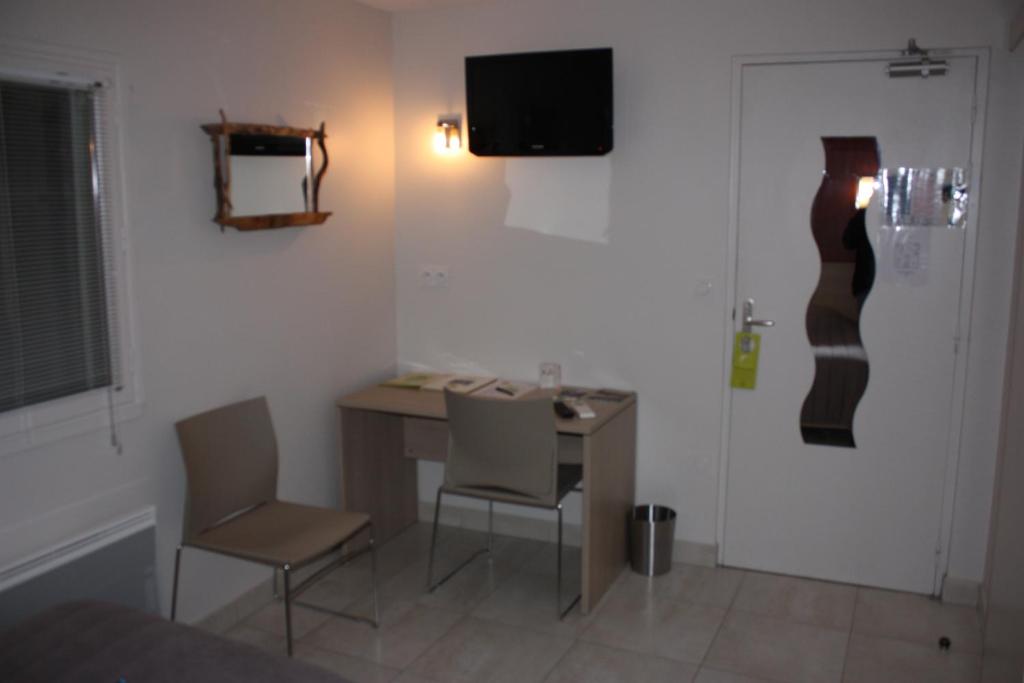 TV a/nebo společenská místnost v ubytování Logis Hotel Restaurant Le Flamant Rose camargue