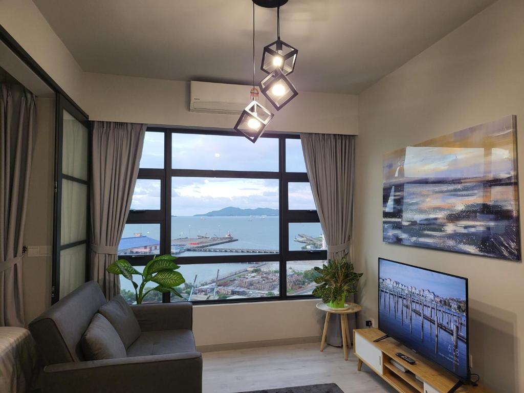 a living room with a large window and a television at Kota Kinabalu Jesselton Quay Seaview with washing machine in Kota Kinabalu