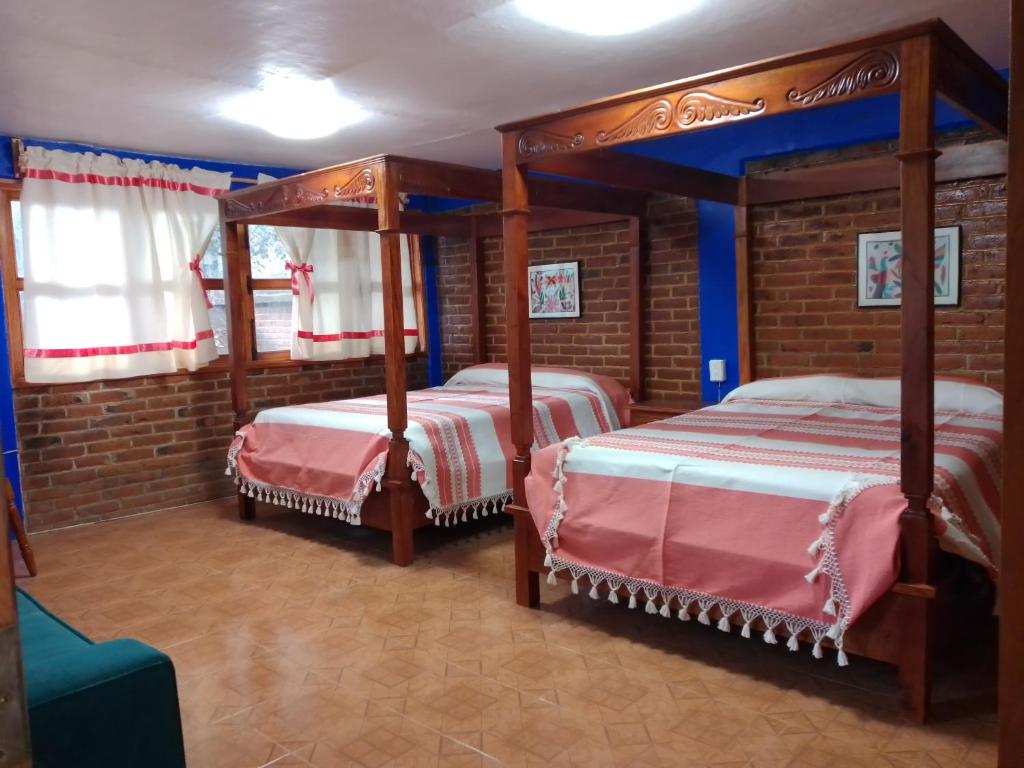 2 camas en una habitación con 2 camas con dosel en COYOACAN DEPARTAMENTO TIPO COLONIAL, en Ciudad de México