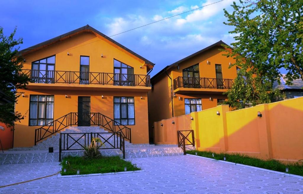 ガバラにあるGabala Double villaの黄色の柵を前にしたオレンジ色の建物