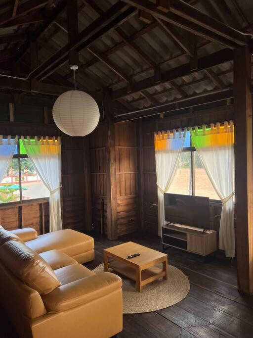 a living room with a couch and a tv at BUA Homestay : cozy house in Laplae district in Uttaradit