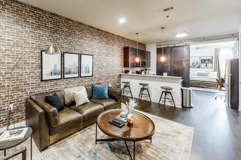 a living room with a couch and a brick wall at Urban Escape in Nashville