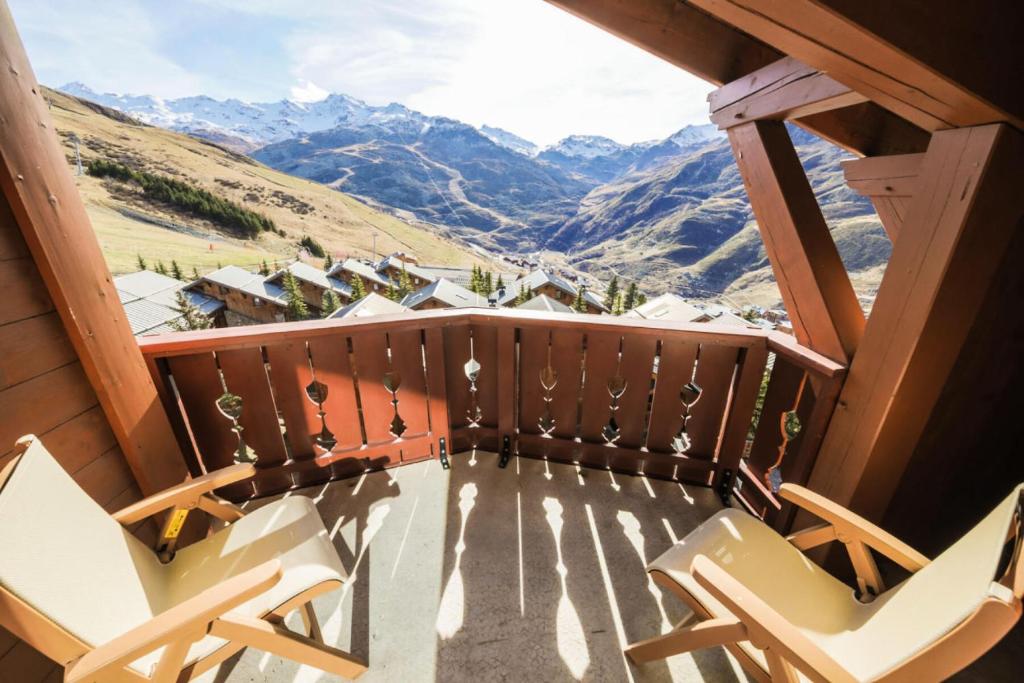 un balcon avec des chaises et une vue sur les montagnes dans l'établissement Résidence Les Alpages de Reberty - maeva Home - Appartement 3 pièces 8 personnes - Sélection MAE-6549, aux Menuires