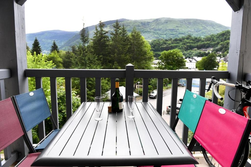 - une table en bois avec une bouteille de vin sur le balcon dans l'établissement Résidence Les Rives de L'Aure - maeva Home - Appartement 2 pièces 6 personnes - Sélection MAE-0074, à Saint-Lary-Soulan